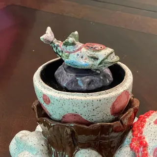 A ceramic egg on top of a mountain with a Wind Fish inside it
